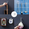 A collection of transparent self-adhesive wall hooks displaying various items like a comb, fork, and a decorative frame.