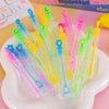 Collection de mini tubes à bulles colorés et cadeaux de fête dans diverses couleurs vives, arrangés sur une assiette blanche.