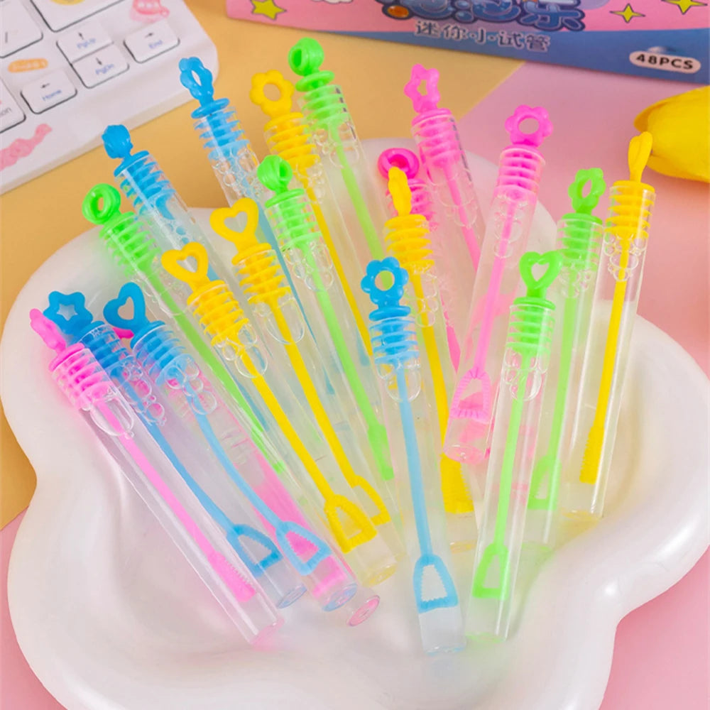 Collection de mini tubes à bulles colorés et cadeaux de fête dans diverses couleurs vives, arrangés sur une assiette blanche.