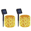 A set of solar powered fairy lights with solar panels, glowing yellow string lights for outdoor garden décor.