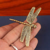 Vintage brass dragonfly desk decor with detailed wings and body held in a hand.