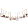 A delicate string of heart-shaped wooden hangers displaying various framed photos and artwork.