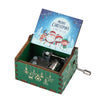 A vintage hand-cranked wooden music box with a green box and a lid featuring a Christmas theme.