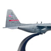 A gray 1:200 scale diecast model of a C-130 Hercules aircraft with the flag of the United States on the tail fin.