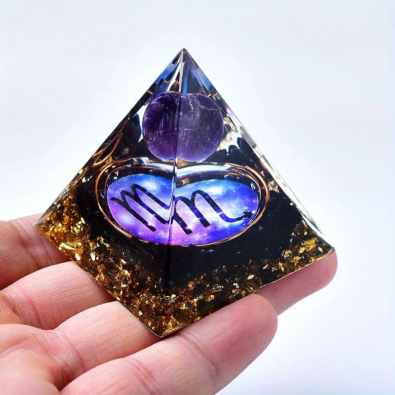 A clear pyramid-shaped crystal featuring purple amethyst and a zodiac sign constellation on its surface.
