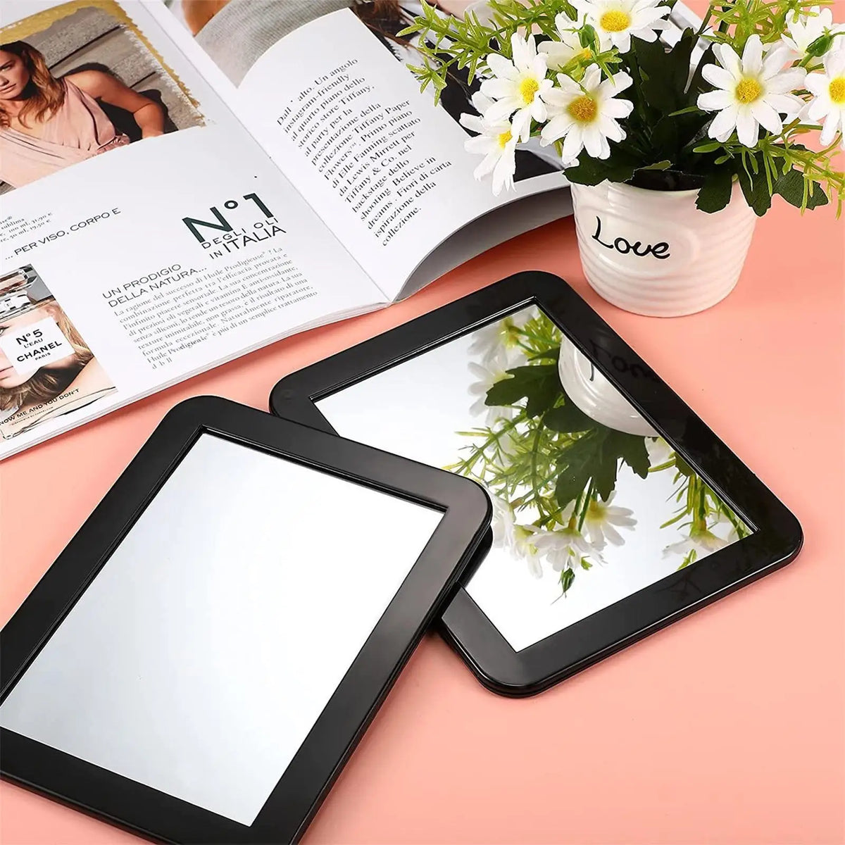 A compact magnetic locker mirror is shown next to a potted white flower arrangement and an open magazine.