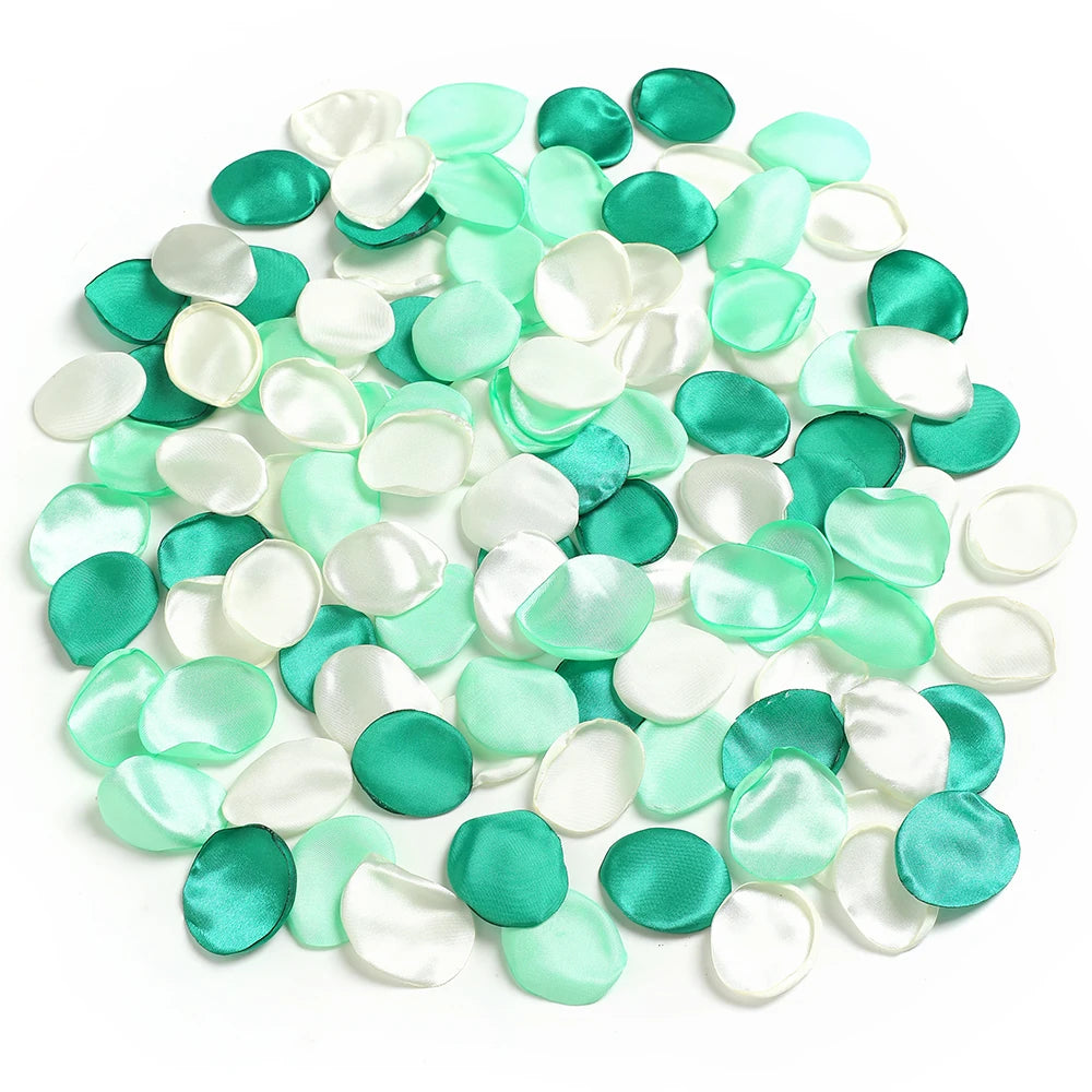 Una colección de pétalos de flores de seda artificial en tonos menta y blanco.