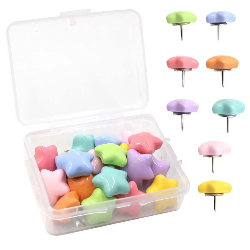 A clear storage box containing various colored decorative pentagram thumb tacks for crafting and display.