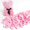 Decoración de espuma de rosa artificial rosa con forma de oso de peluche y pétalos de rosa sueltos.