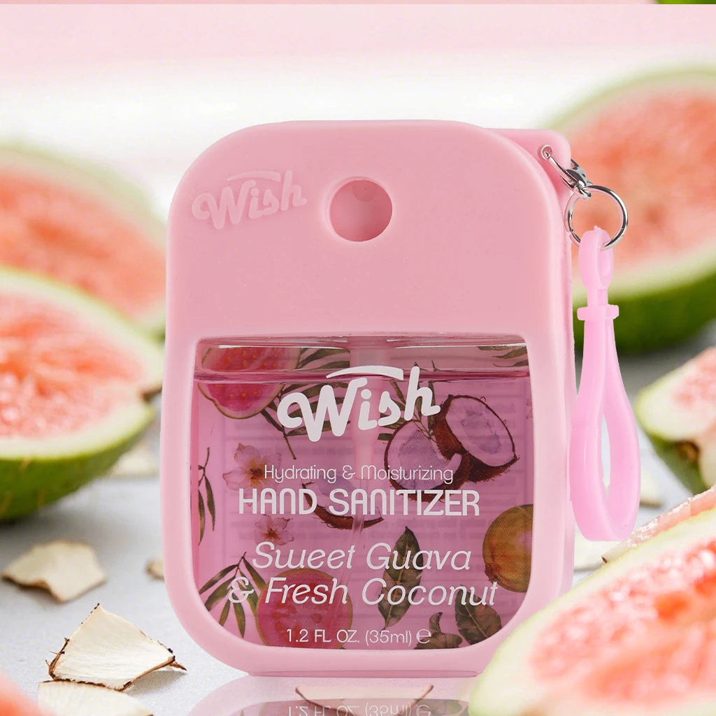 A pink bottle of Wish hydrating and moisturizing hand sanitizer spray with a lime and coconut fragrance next to cut guavas.