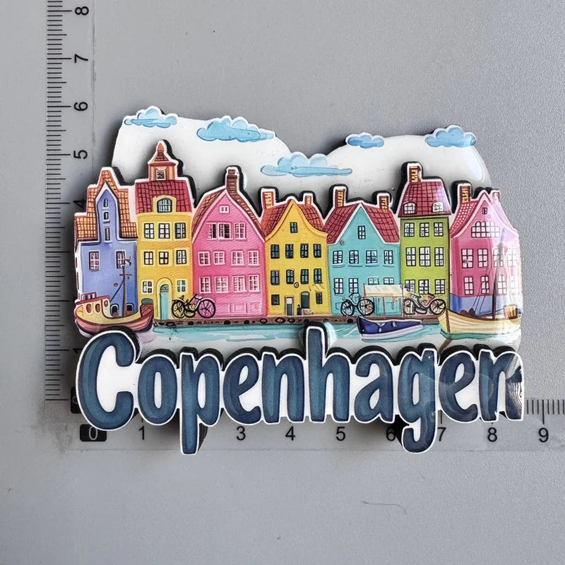 A collection of colorful wooden fridge magnets depicting houses and a cityscape for Copenhagen