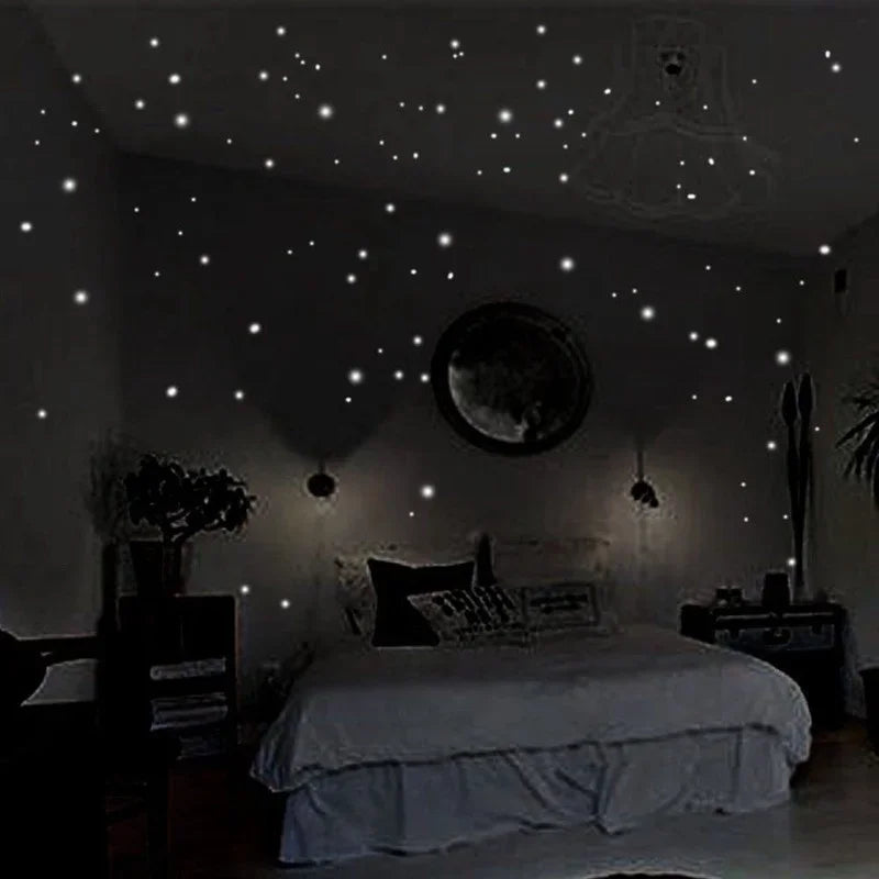 A bedroom wall decorated with glow-in-the-dark star stickers and a moon, illuminating a bed.