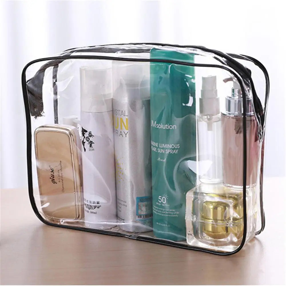 A clear waterproof toiletry bag containing various cosmetic bottles and a glass oil bottle.