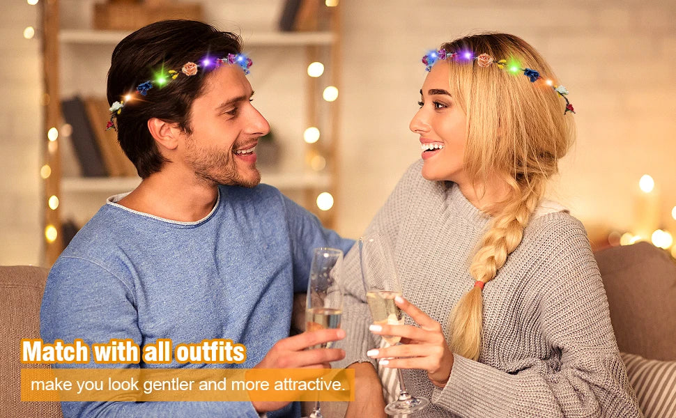 A smiling couple wearing glowing flower wreath headbands while looking at each other.