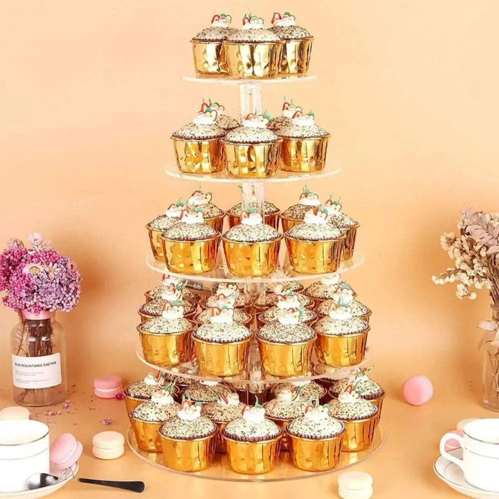 Mehrstufige transparente Acryl-Präsentationsständer mit goldenen Cupcakes und weißer Glasur auf hellem Hintergrund.