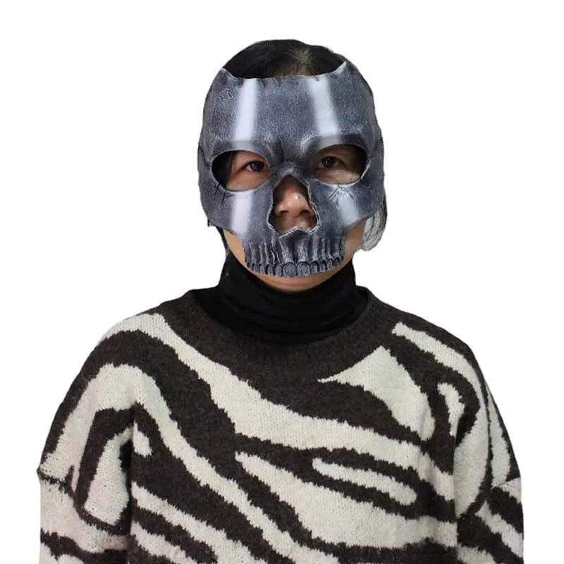 A person wearing a full face resin mask shaped like a Halloween skeleton ghost over a patterned sweater.