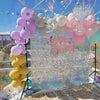 A sparkling backdrop for celebrations featuring iridescent sequin wall panels and clusters of pink and purple balloons.