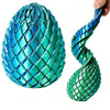A close-up of a teal dragon egg fidget toy with a textured, scale-like surface being held by a hand.