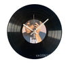 A black vinyl record is used as a decorative wall clock, featuring a face with hands pointing to the hour.
