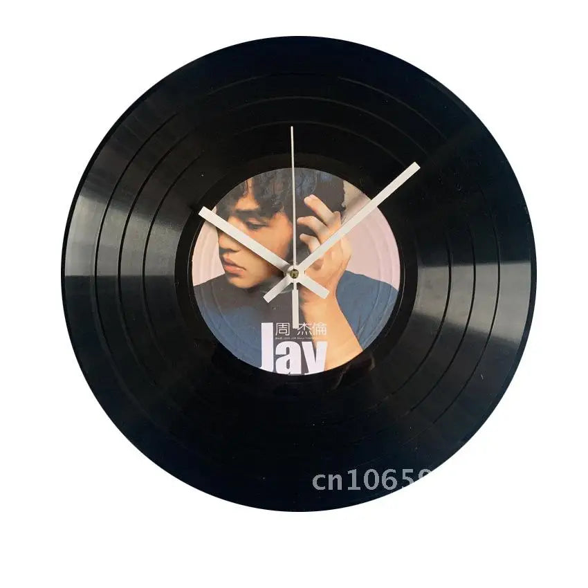 A black vinyl record is used as a decorative wall clock, featuring a face with hands pointing to the hour.