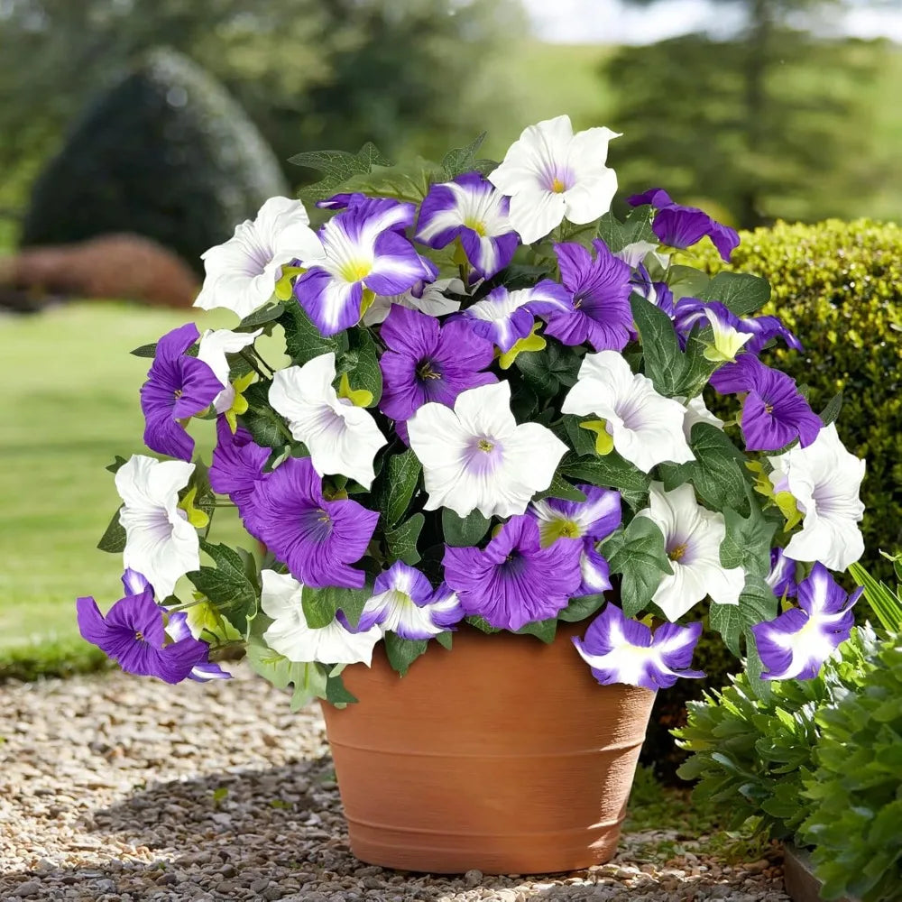 A potted arrangement of artificial petunia flowers featuring purple and white blooms.