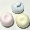 Three squishy toys shaped like cat paws in pastel colors pink blue and yellow
