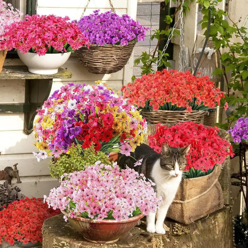 A vibrant bouquet of artificial violet flowers in various shades of pink, purple, and red displayed on a wooden shelf.