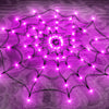 A glowing purple spider web pattern made of LED string lights on a textured surface.