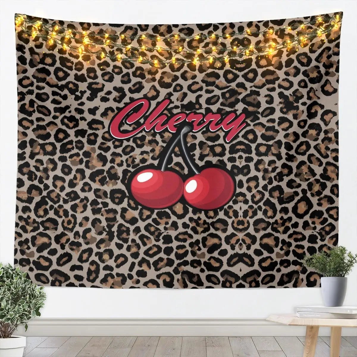 A tapestry wall hanging featuring a leopard print background with string lights and a cherry graphic.