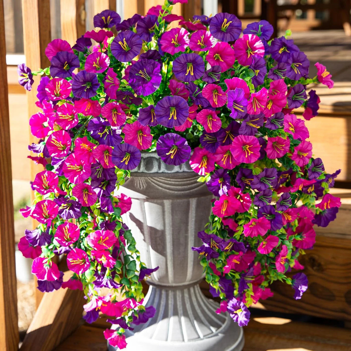 A vibrant silk morning glory vine wreath featuring purple and pink flowers displayed in a white pedestal vase.