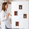 A woman stands next to a white board displaying several framed pictures of cats.