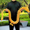 A person holds a long, yellow, dragon-like ornament made of resin for decoration.