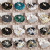 Various marble print waterproof round tablecloths in black, gold, and white patterns displayed on chairs.