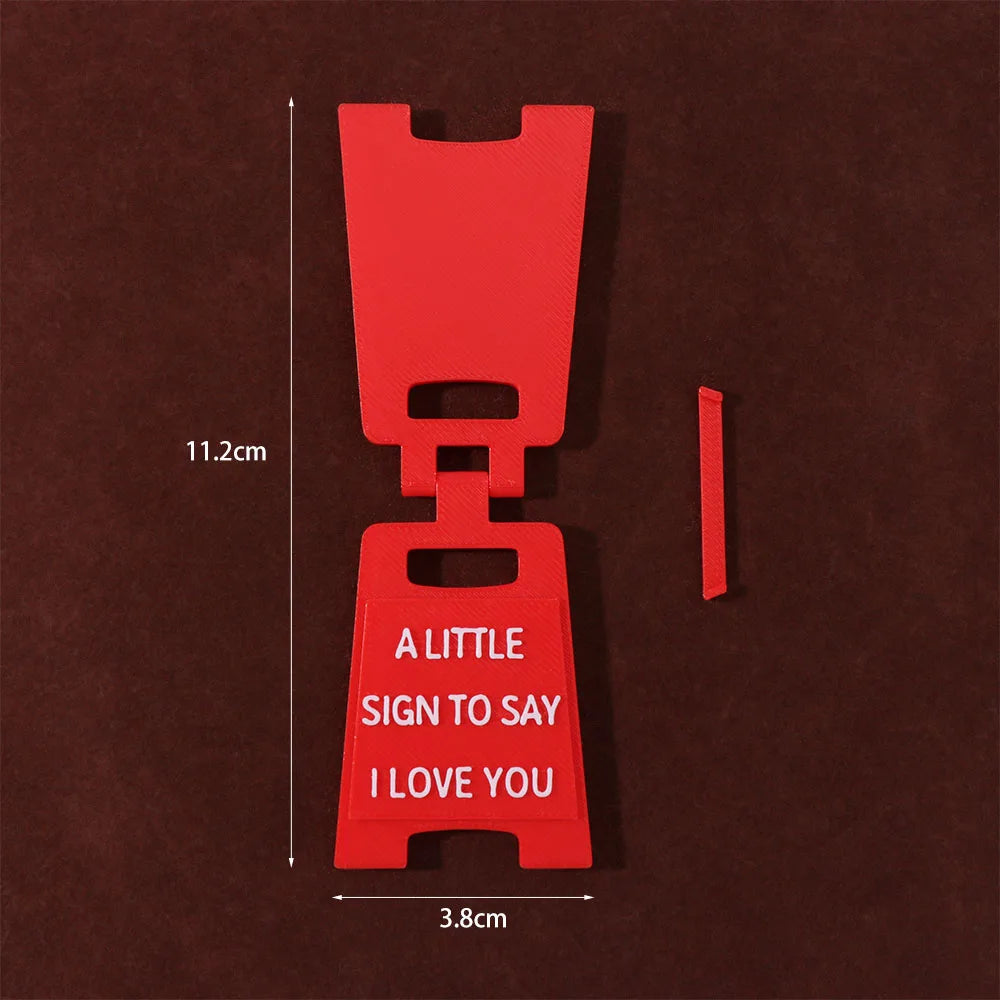 A red 3D printed letter sign ornament shaped like a hand with the text I love you on it.