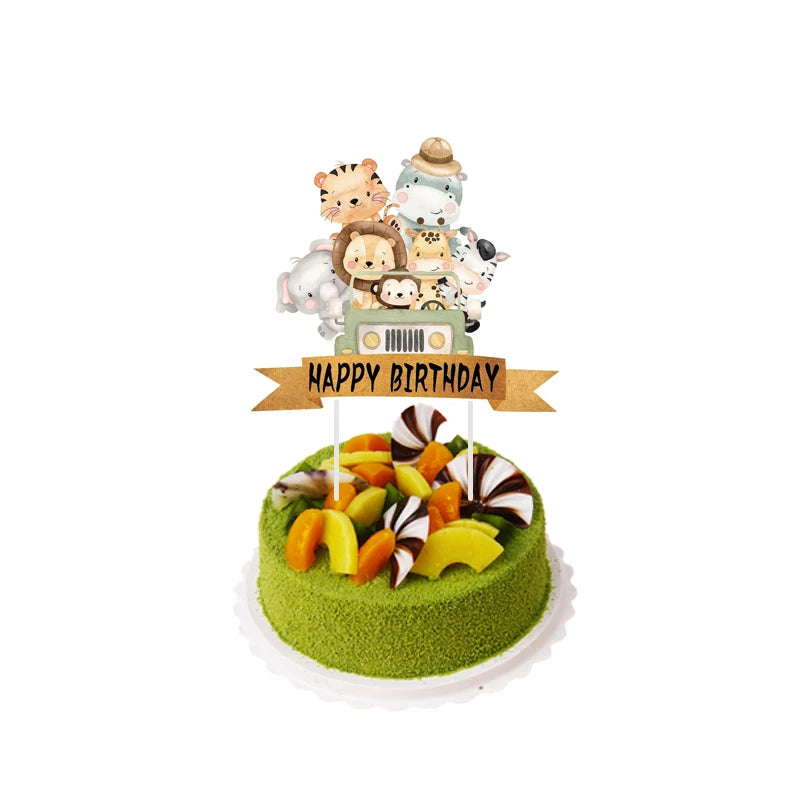 A tiered birthday cake decorated with jungle safari animal figures and a happy birthday banner