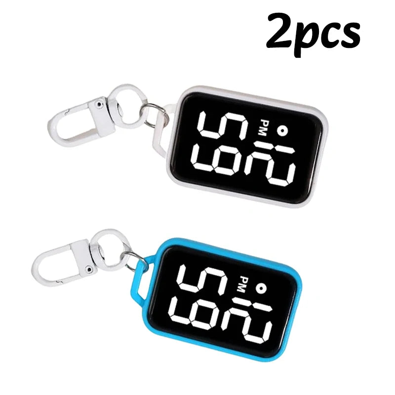 A pair of LED keychain pocket watches with digital displays, one silver and one blue.