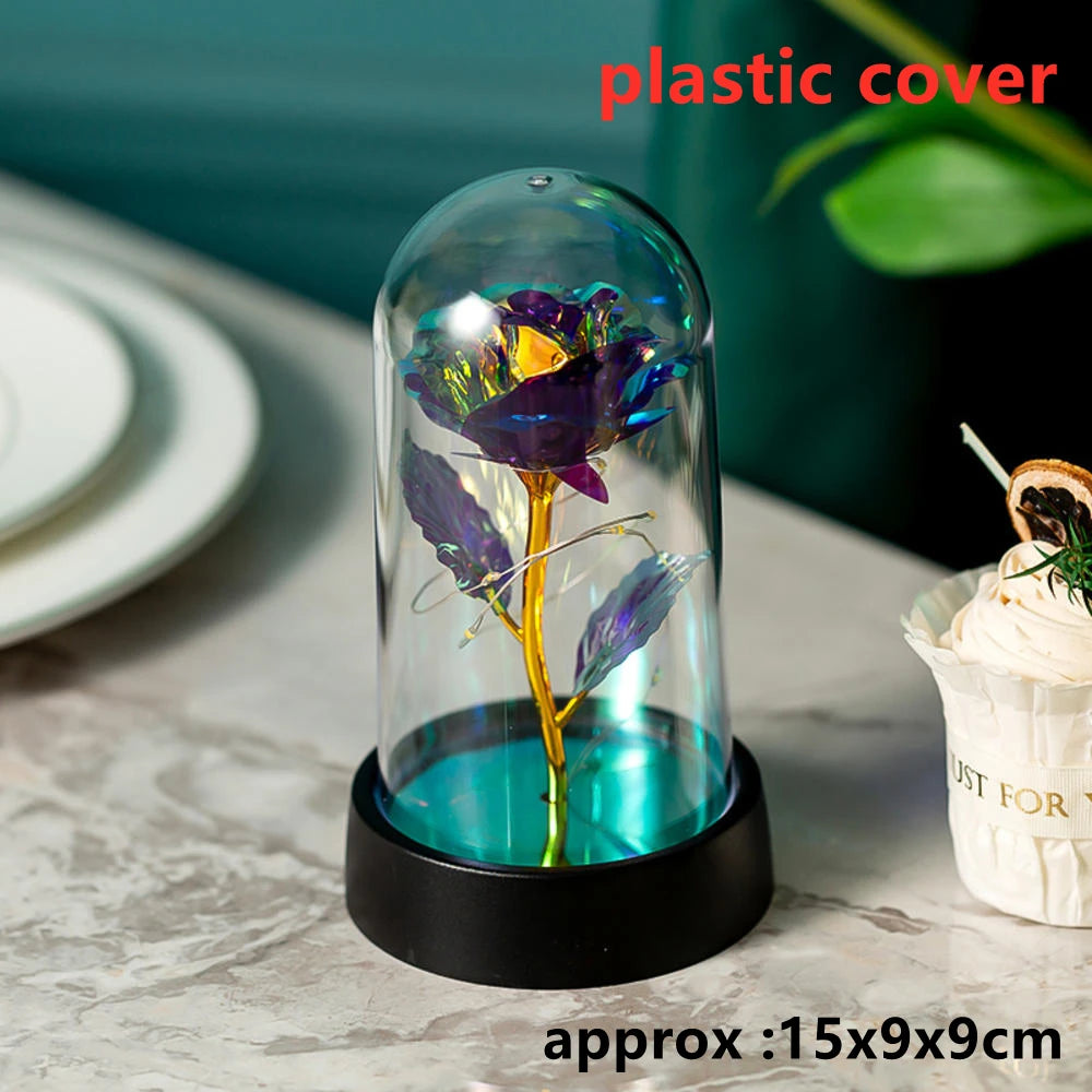 A glass dome containing an LED galaxy rose artificial flower on a black base.