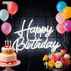 A glowing neon sign spelling out Happy Birthday made of white light on a dark background with balloons and a cake.