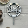 Silver acrylic birthday cake topper featuring the words Happy Birthday on a circular design with a stick.