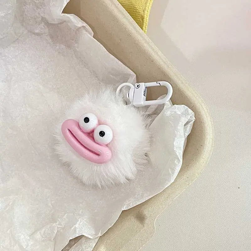 A white fluffy plush charm shaped like a sausage mouth with pink lips and two large eyes, attached to a silver keychain.