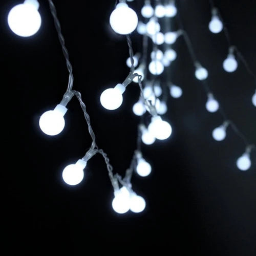 A close-up shot of a string of white globe LED lights hanging against a dark background.