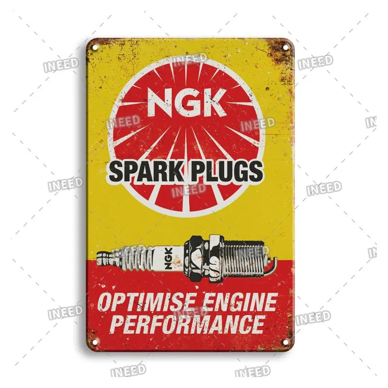 Vintage metal garage sign with red and yellow paint featuring the text NGK Spark Plugs and Optimise Engine Performance