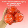 A hand holds several realistic watermelon-colored, soft and squishy stress relief toys.