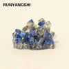 A cluster of blue and clear quartz crystals with gold inclusions used as a Reiki amulet or decorative figurine.