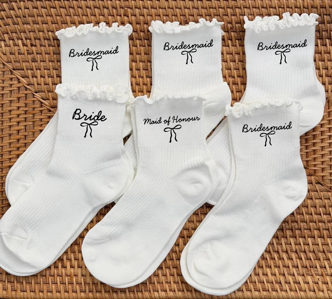 A set of white socks for a bridal party, including bridesmaid and bride designs.