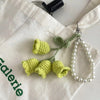 Handmade pearl chain orchid key ring attached to a white fabric background.