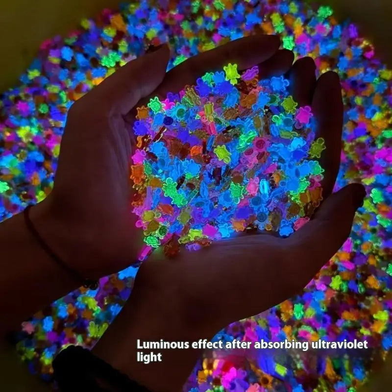 A hand holds a pile of luminous, multicolored resin turtle figurines that glow after absorbing ultraviolet light.