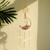 A handcrafted gold pendant featuring a lotus flower and a crescent moon made of purple crystal and clear glass beads.