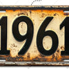 Señal de pared de aluminio vintage con el año 1961 grabado en una superficie desgastada y envejecida.