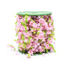 A cylindrical arrangement of pink roses, pearl beads, and green leaves used as a floral garland ribbon.